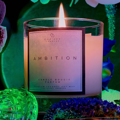 Candle labeled 'Ambition' with decorative flowers and greenery in the background