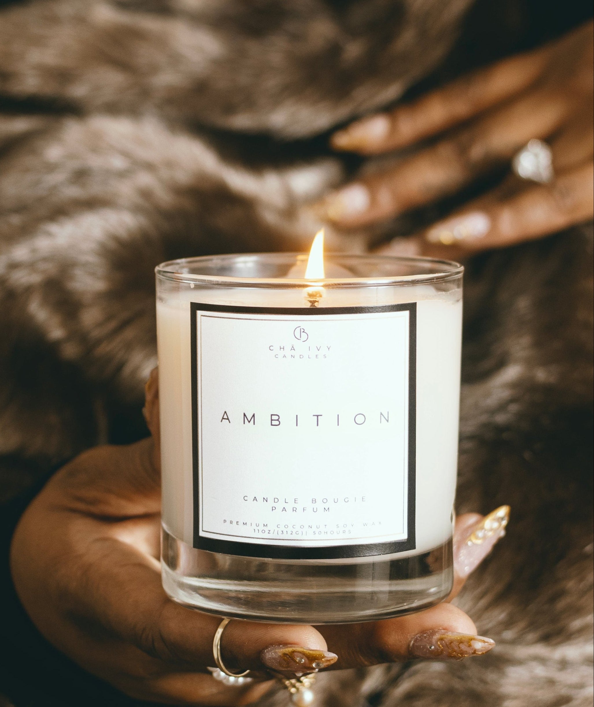 holding 11oz ambition luxury candle with gold nails 